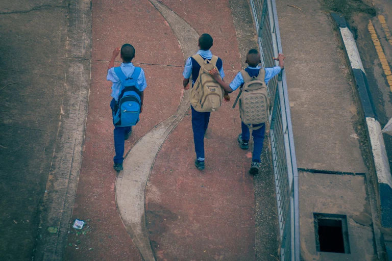 Boys in school uniform with backpacks, seen from above