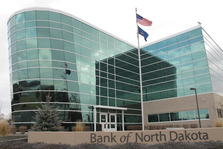 A big glassy building stands behind a low wall that says 'The Bank of North Dakota.'