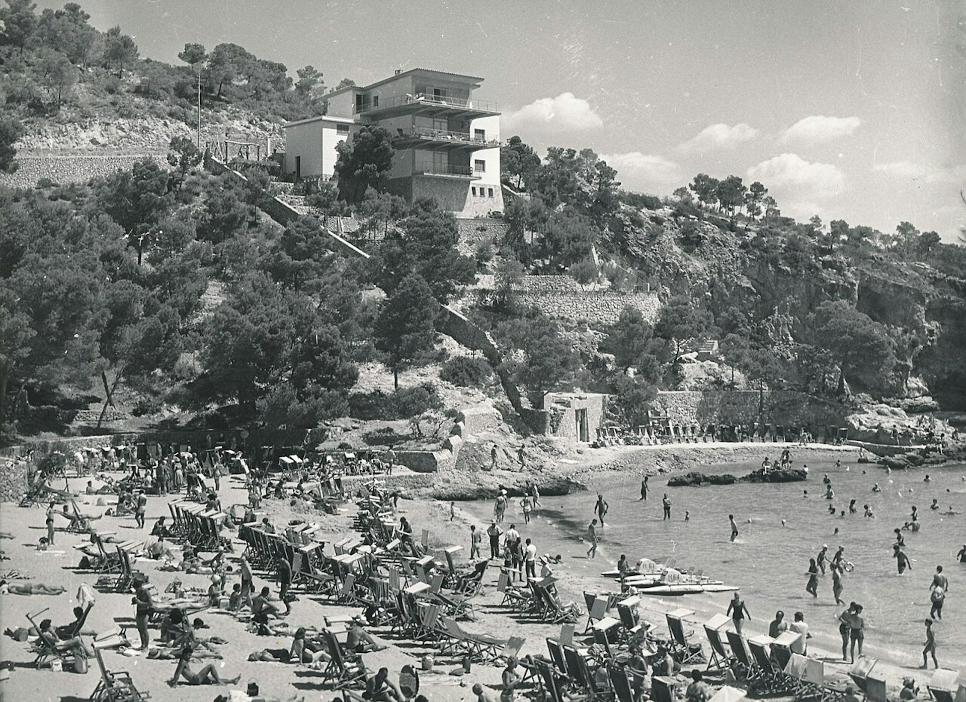Imagen en blanco y negro de una playa llena de gente.
