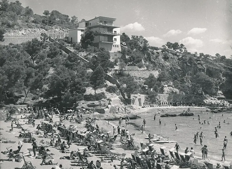 Imagen en blanco y negro de una playa abarrotada de gente.