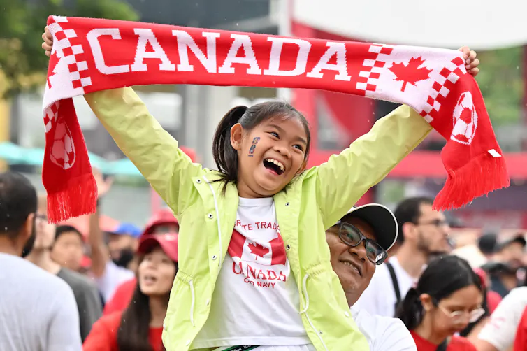 Una joven sostiene un pañuelo que dice Canadá.