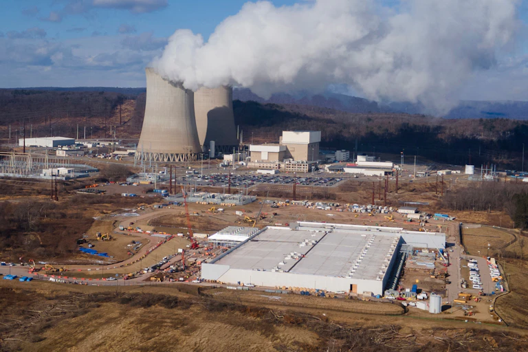 A data center owned by Amazon Web Services, in the foreground, is under construction next to the Susquehanna nuclear power plant in Berwick, Pa.
