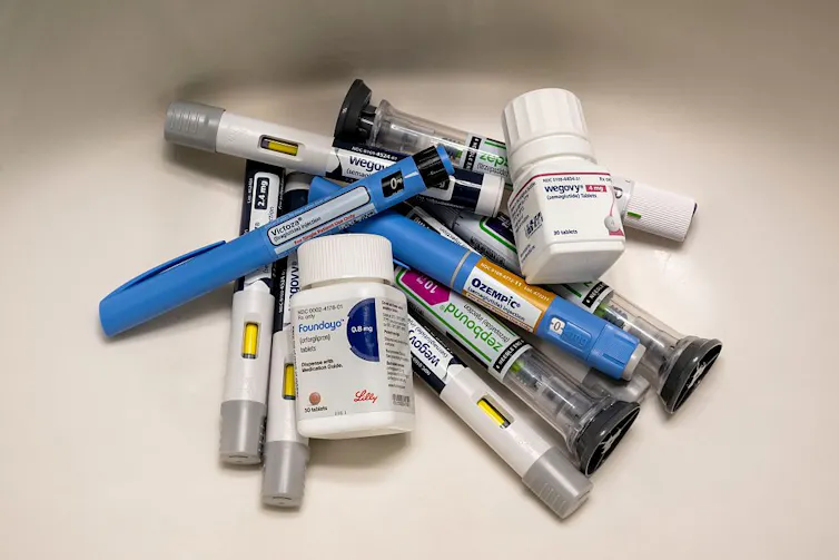 Various types of GLP-1 drug syringes and bottles in a pile