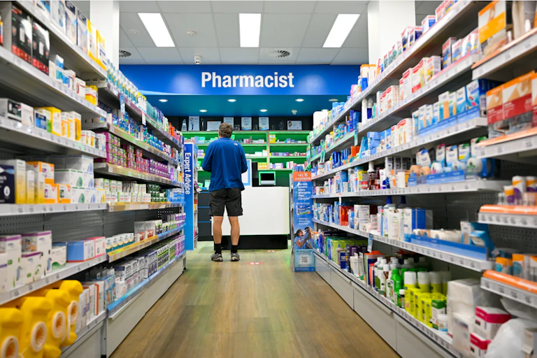 A man waits at the counter to see a pharmacist