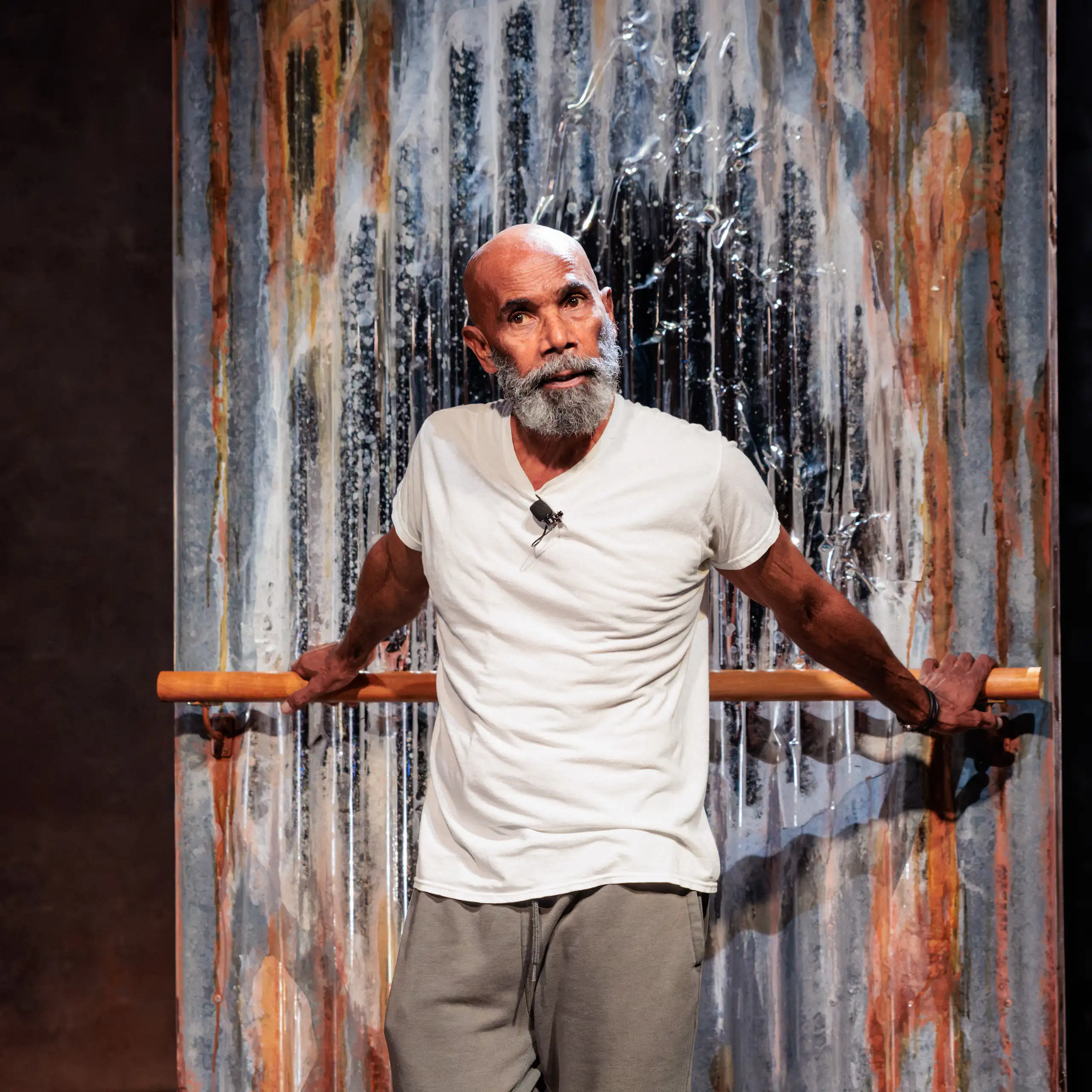 An older Aboriginal man with a grey beard performs onstage.