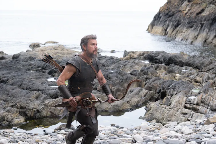 Matt Damon as Odysseus running along a rugged coast