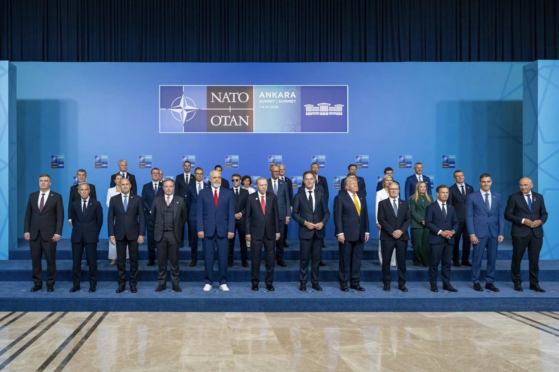 Foto de muchos presidentes de países ante un fondo con las siglas de la OTAN