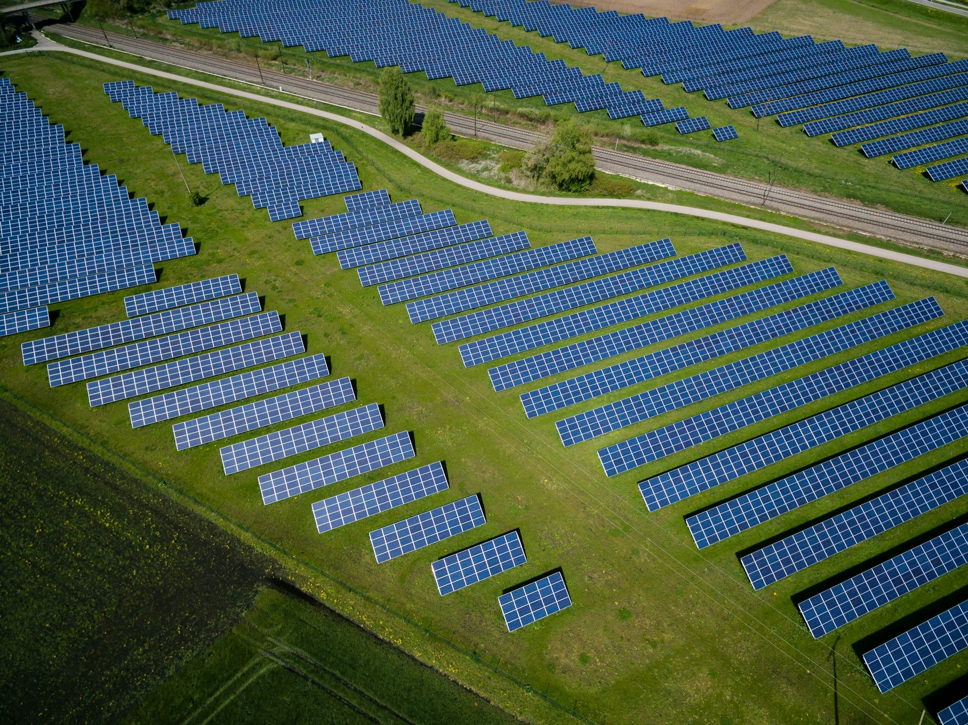 Filas de paneles solares en campos verdes.