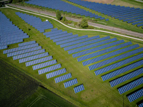 Rows of solar panels on green fields.