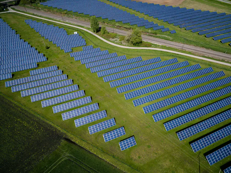Rows of solar panels on green fields.