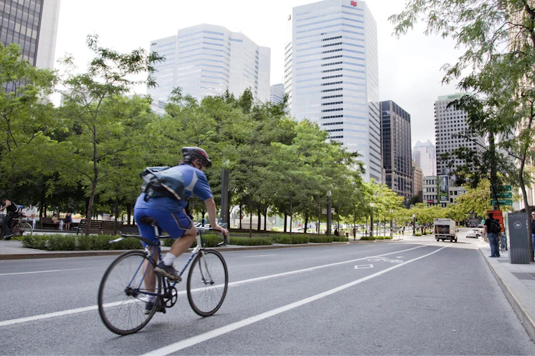 a man on a bike rides along a street