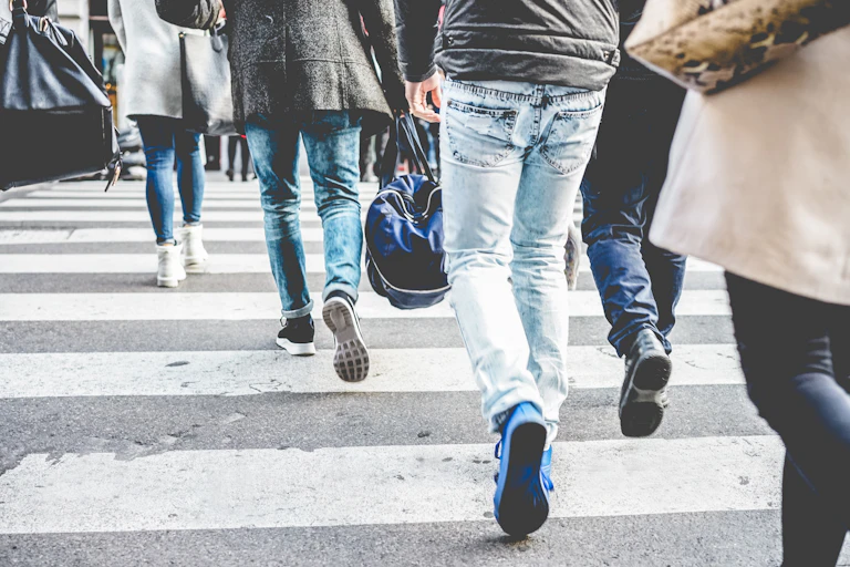 Crowd of people walking on zebra crossing street city center -