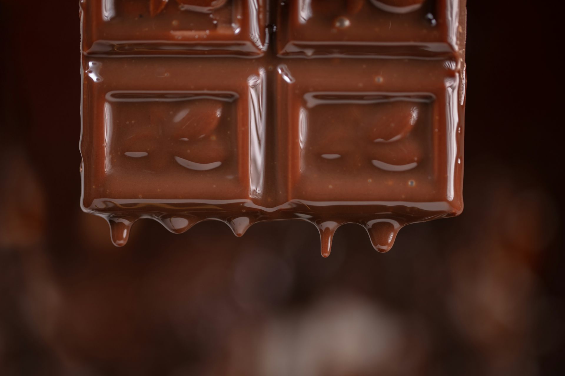 Un trosset de xocolate es fon i deixa caure gotetes.