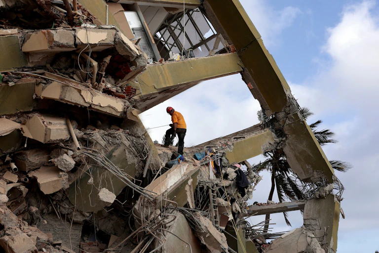 Un rescatista trabaja en el lugar donde se derrumbó un edificio tras los fuertes terremotos mientras continúan las operaciones de búsqueda, rescate y recuperación en La Guaira.