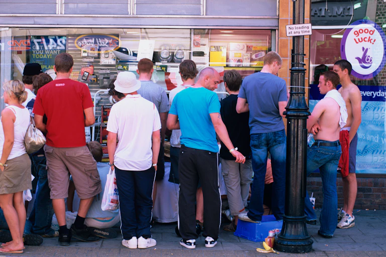 Some people crowding around a shop window in England