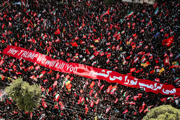 Aerial shot of a crowd in the city of Mashhad displaying a banner reading: 'Hey Trump, we will kill you'.