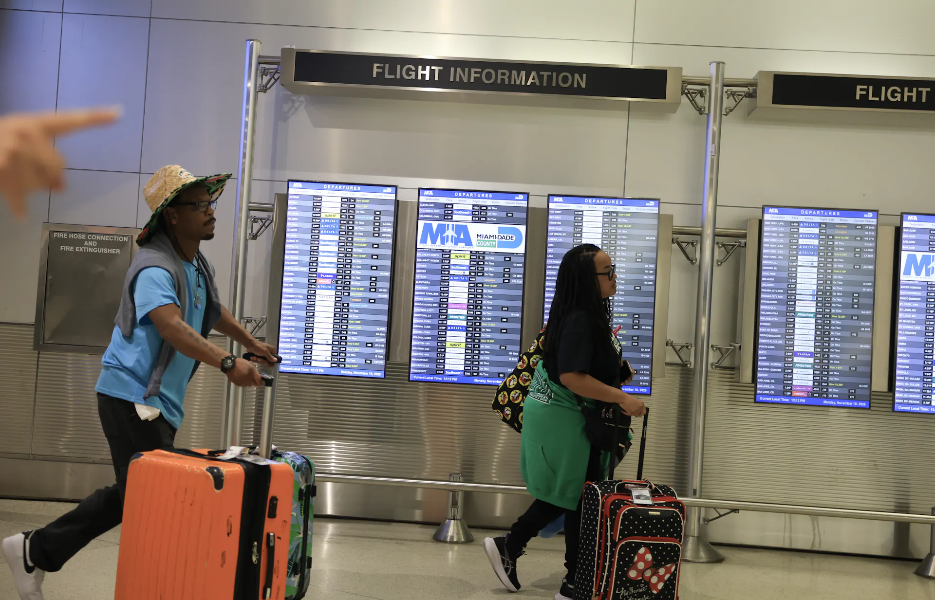 People with suitcases walking through Miami International Airport