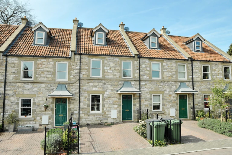 A terrace of houses with paved driverways.