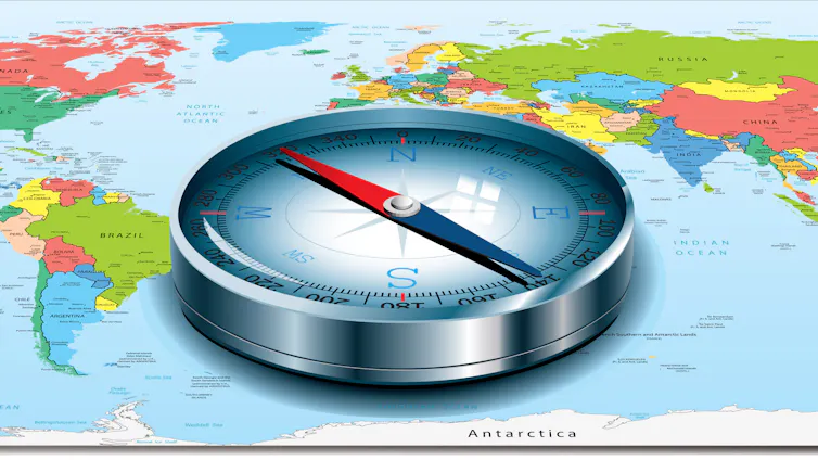 A compass placed on a world map with its needle directed toward the U.S.