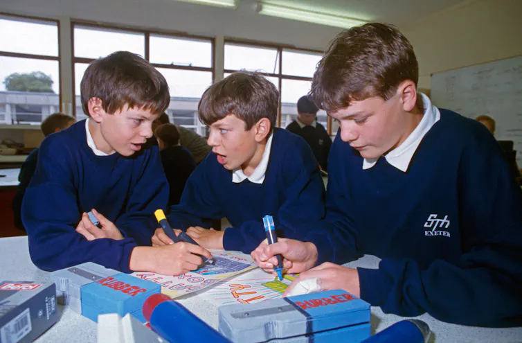 Three grade 10s in a classroom