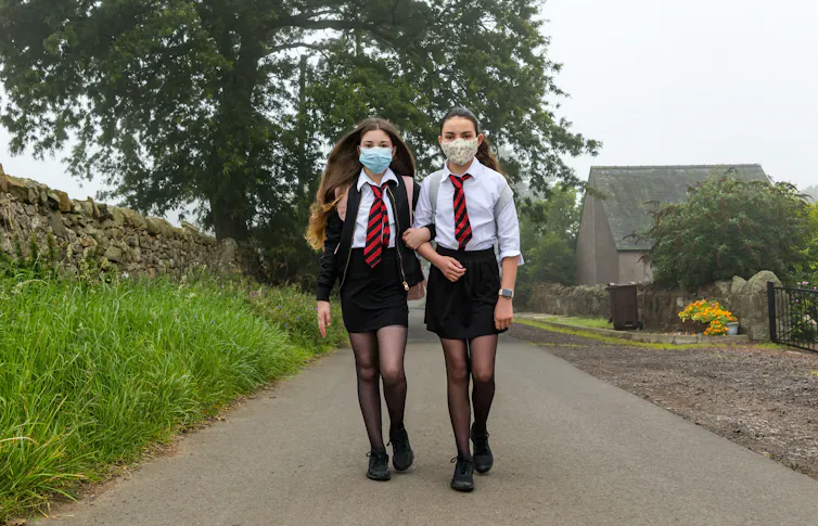 Two girls going to school in face masks