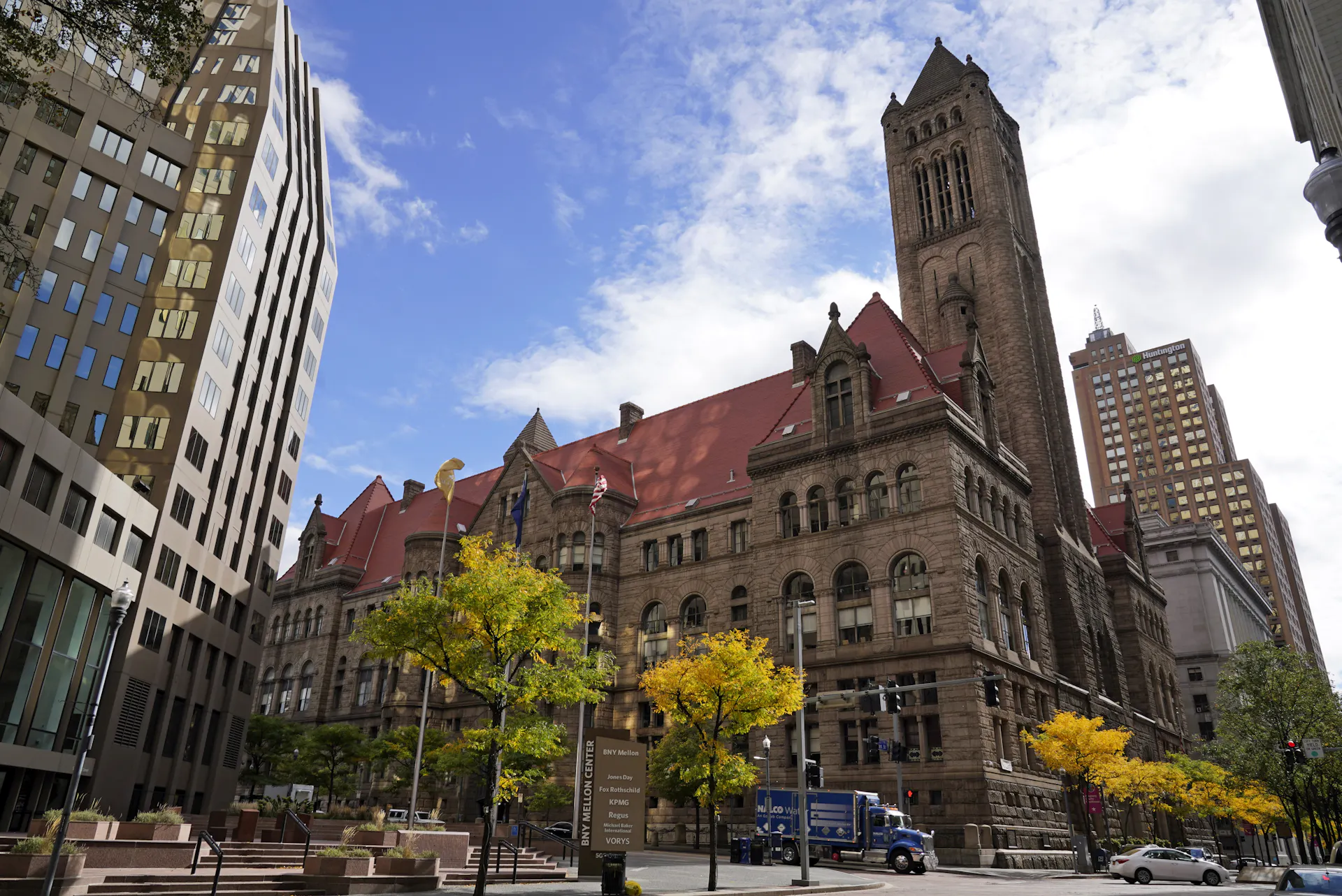 A large, old stone building in the middle of a city.