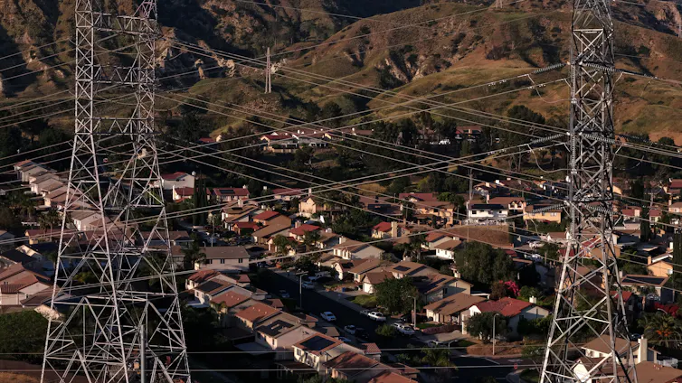 Transmission towers and power lines above a hillside neighborhood