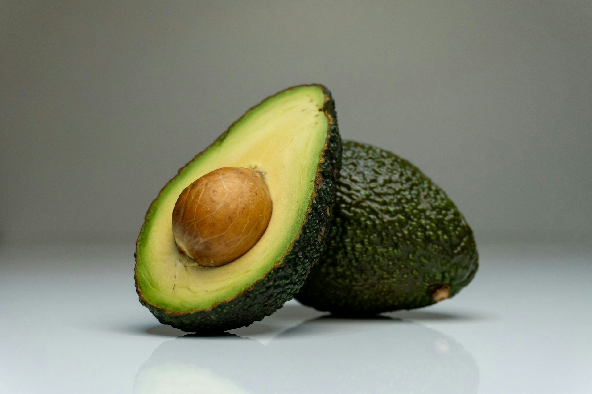 An open avocado, seed pointed out