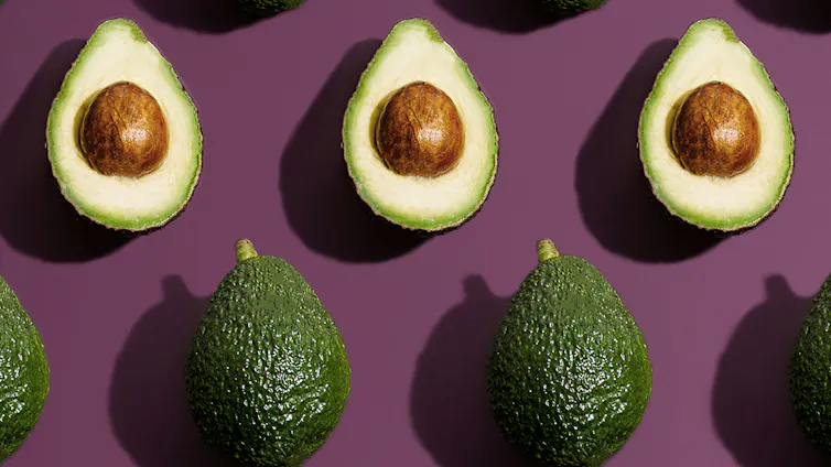 Rows of avocados sliced open showing the seed.