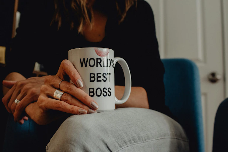 A close up of a 'world's best boss' mug being held on a woman's lap