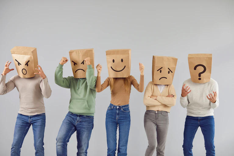 people with brown paper bags over heads, faces smily/angry drawn onto paper bags