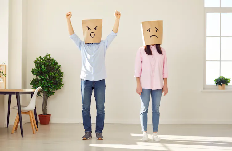 two people standing with paper bags on heads, angry and sad pen faces