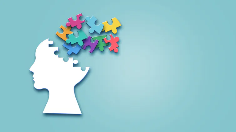 A side silhouette of a human head, with puzzle pieces coming out of the top of the head.