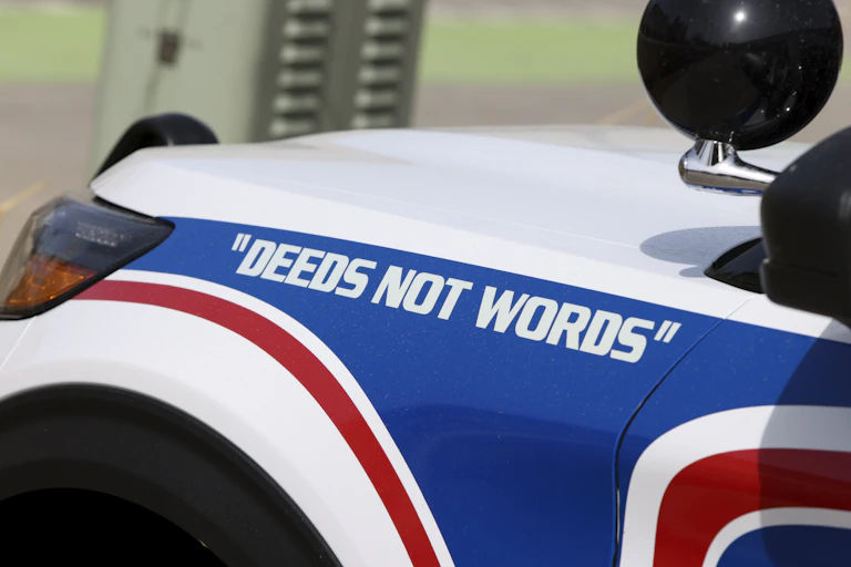A police cruiser with the slogan 'deeds not words