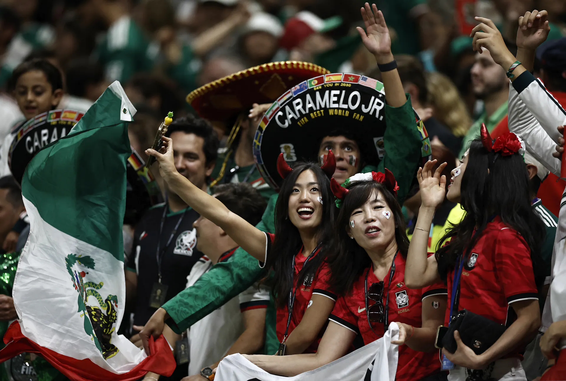 Soccer fans wave flags in a stadium.