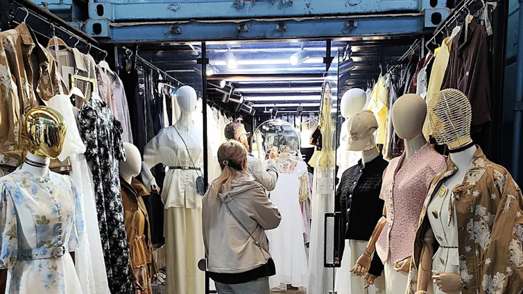 People shopping at clothes store on market