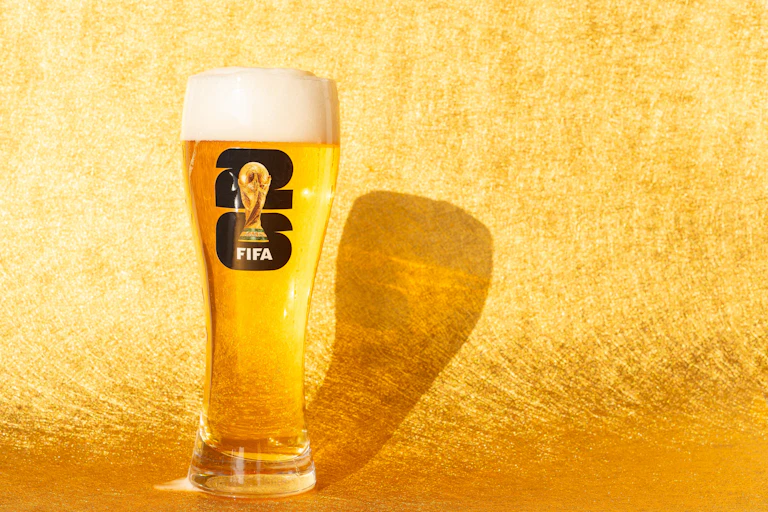 Beer in glass with World Cup logo.