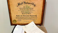 Diploma, carta y carpeta enmarcados sobre la mesa