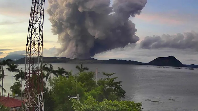 A cloud of ash rising from a volcano in a lake