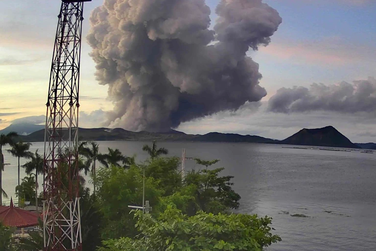 A cloud of ash rising from a volcano in a lake