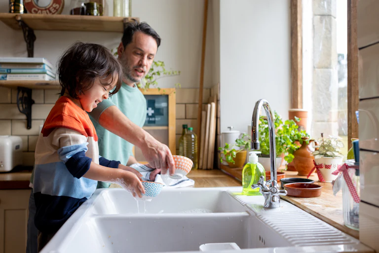 Kid helping out with chores by doing dishes