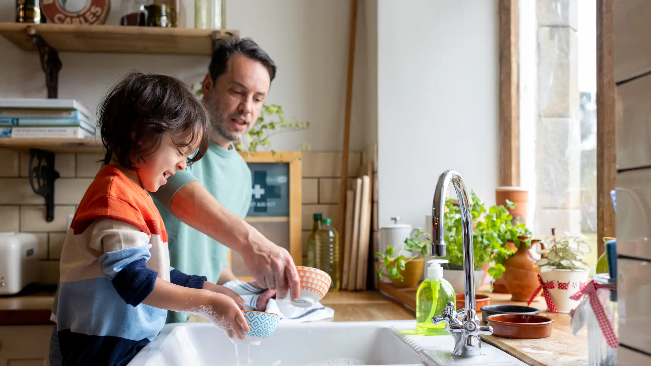 Kid helping out with chores by doing dishes