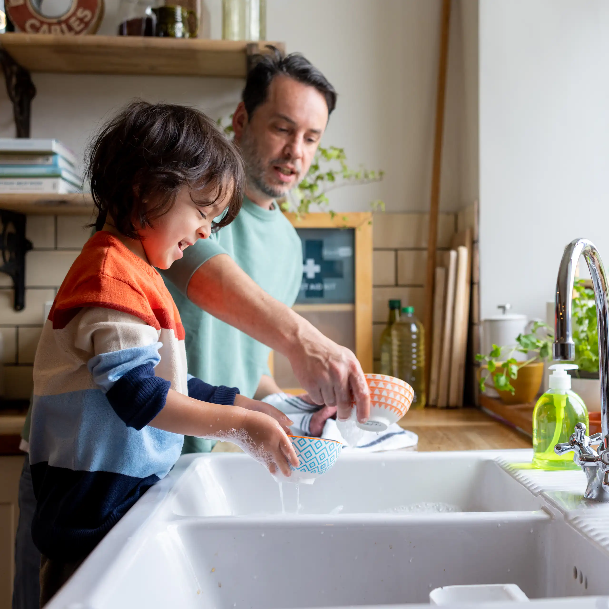 Kid helping out with chores by doing dishes