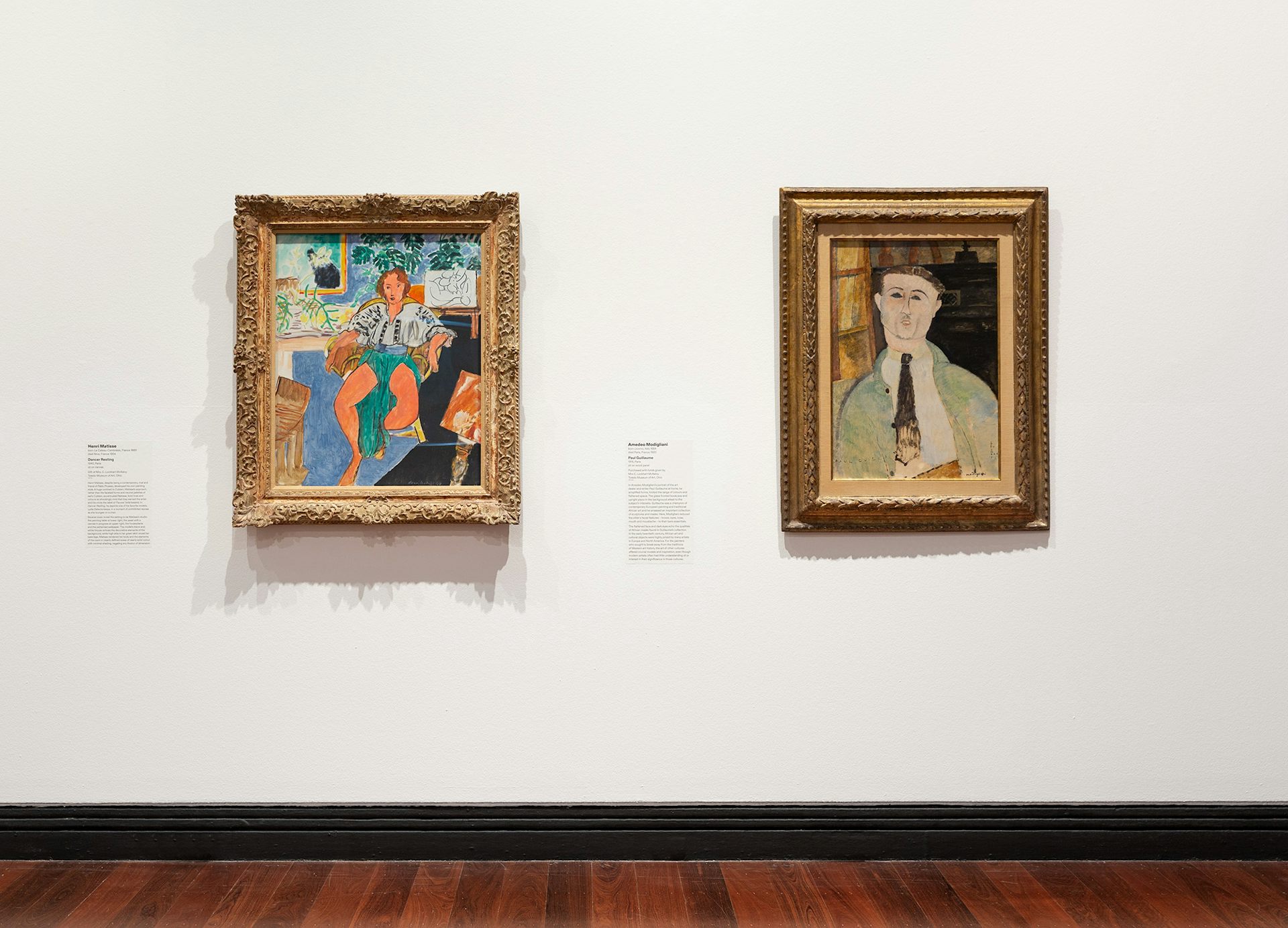 Two paintings in a gallery: portraits of a dancer, and a man.