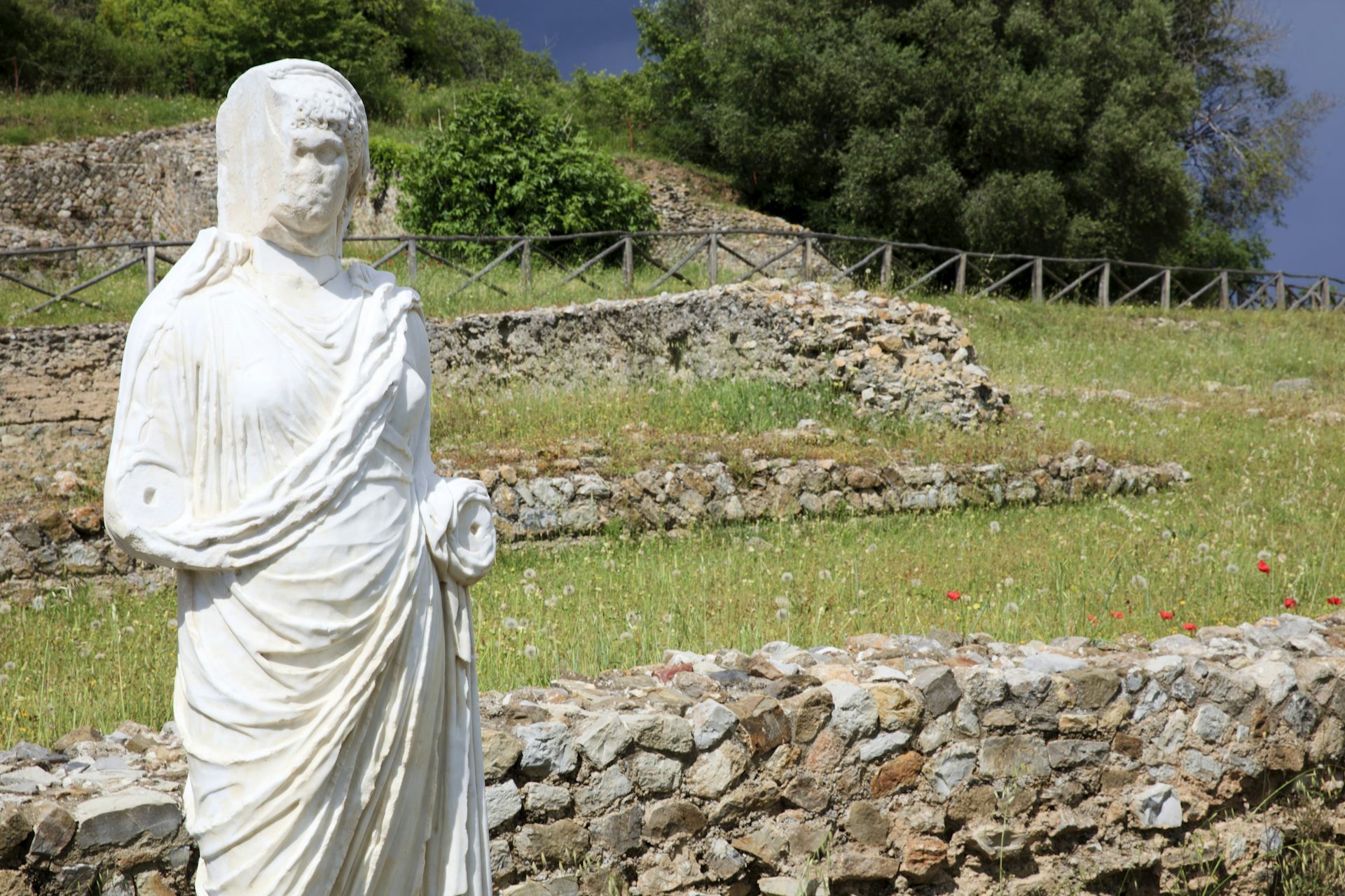 Une statue se dresse au milieu des vestiges d'un site de la Rome antique.
