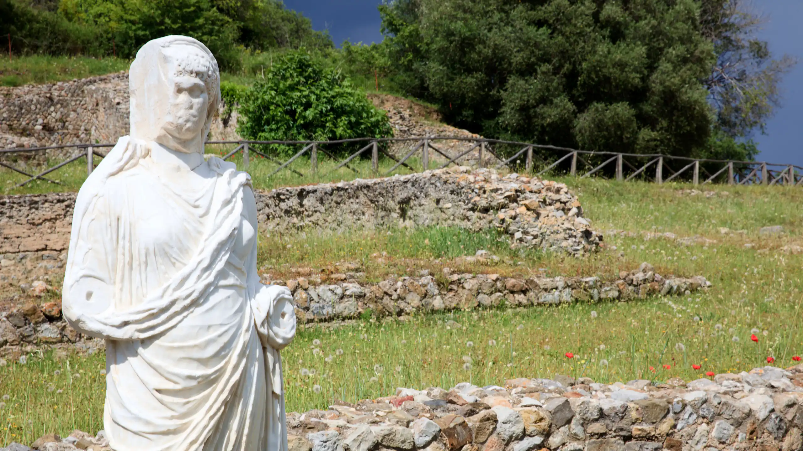 Une statue se dresse au milieu des vestiges d'un site de la Rome antique.