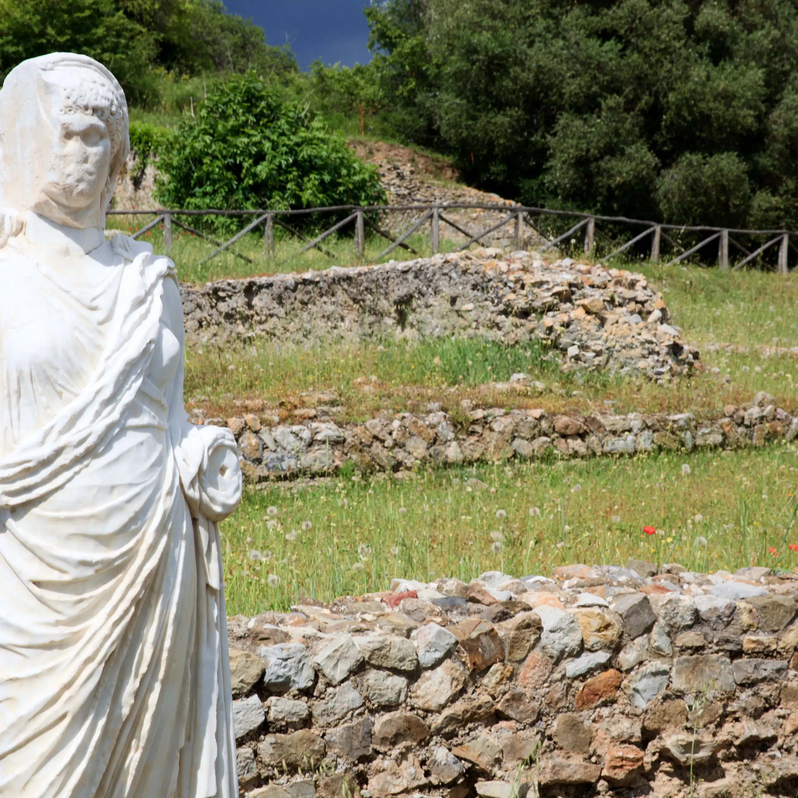 Une statue se dresse au milieu des vestiges d'un site de la Rome antique.