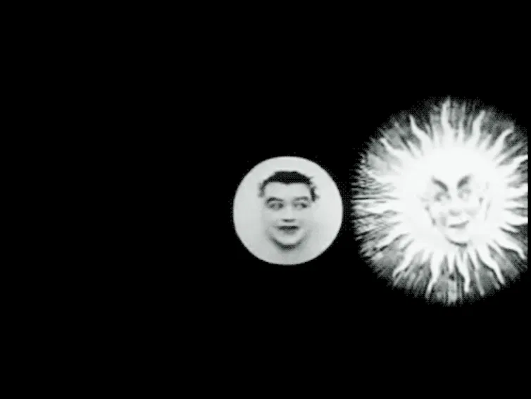 Imagen en movimiento de un sol con cara humana escondiéndose detrás de una luna también con cara humana.
