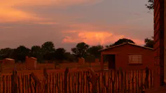 A modest 2 bedroomed house in the sunset with outside toilets all around it.