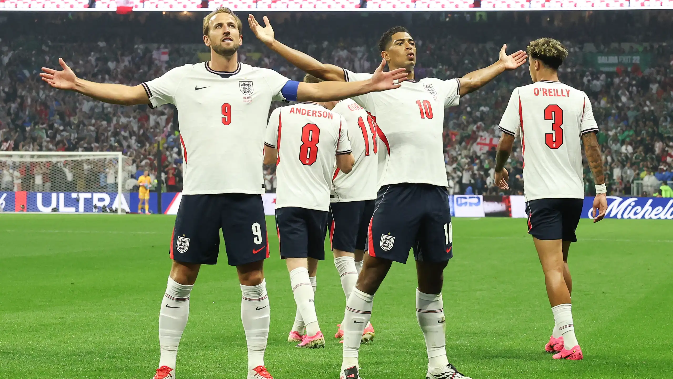 harry kane and jude bellingham acknowledge the crowd with their arms outstretched after england's win over mexico